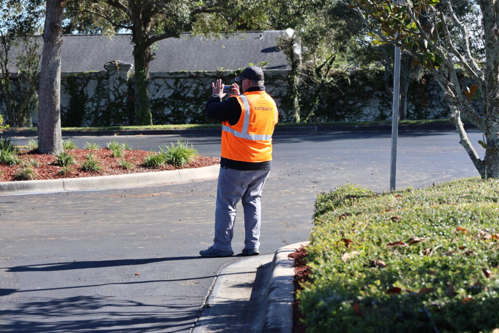 Exterity employee taking photos of a commercial building's landscape